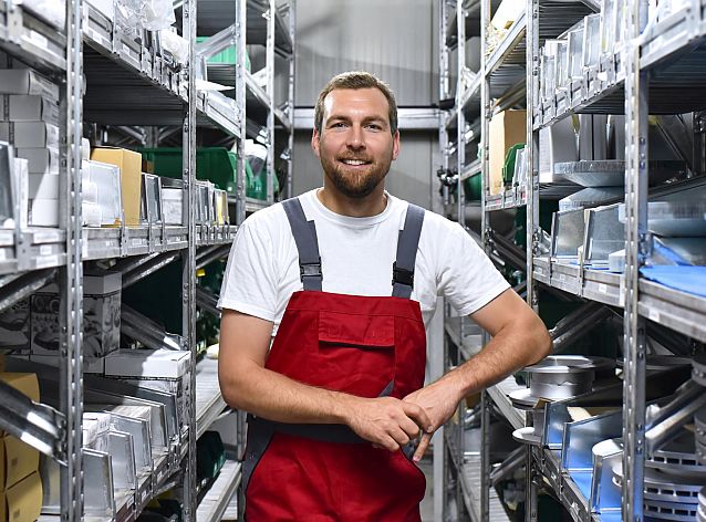 Mitarbeiter in Arbeitskleidung in einem Warenlager im Handel // Employees in work clothes in a warehouse in the trade